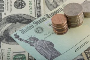 refund check with cash and stacks of coins