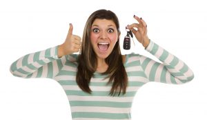 Pretty Ethnic Female with New Car Keys and Thumbs Up Isolated on a White Background.