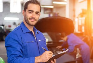 View of a Young attractive mechanic working at the garage